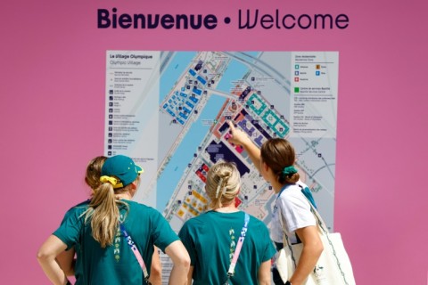 Members of the Australian delegation study a map of the Athletes' Village