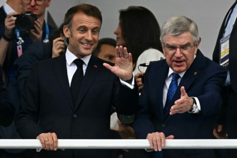 French President Emmanuel Macron International Olympic Committee president Thomas Bach wave to the crowd at the opening ceremony