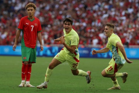 Juanlu Sanchez (C) runs away in celebration, chased by Fermin Lopez, after netting Spain's winning goal against Morocco in Marseille