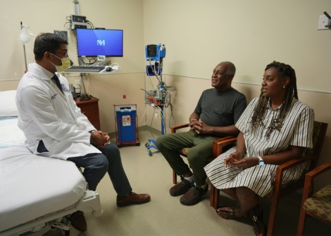 Doctor Satish Nadig (L), professor of surgery at the Northwestern University-Feinberg School of Medicine, speaks with patient, Harry Stackhouse (C), 74, and his daughter Trewaunda Stackhouse, 45, in a clinic post-transplant room at Northwestern Medicine 