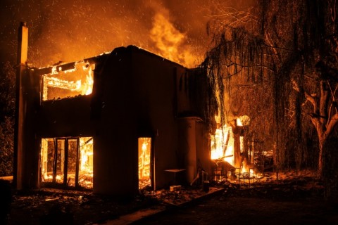 A wildfire burns a hillside in Varnavas, north of Athens. Thousands of people have been evacuated