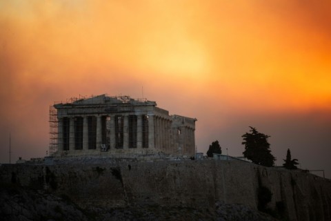 Volunteers try to extinguish a wildfire northeast of Athens that has forced the evacuation of thousands of people in suburban towns