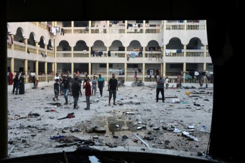 Displaced Palestinians gather in the yard of a school hit by an Israeli strike in Gaza City