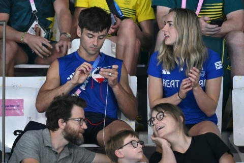 When he wasn't in the pool at the Olympics, Britain's Tom Daley (L) was spotted enjoying the Games from the stands while knitting