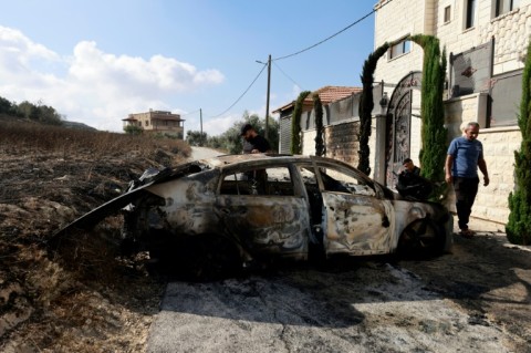 Palestinians inspect the damage from a deadly attack by armed Jewish settlers on the village of Jit in the Israeli-occuped West Bank