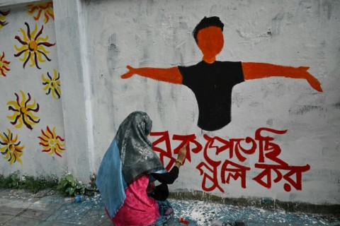 A student creates a mural which says 'Shoot me in the chest' in Bangla language to depict Abu Sayeed, the first student slain in a police crackdown on protests