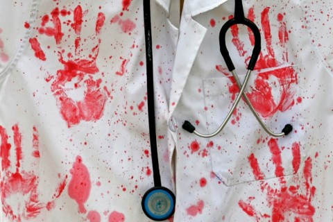 A lab coat covered with red ink hand prints as a protest symbol in Vijayawada