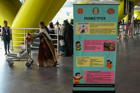 Passengers walk past a mpox awareness banner at Anna International Airport terminal in Chennai 