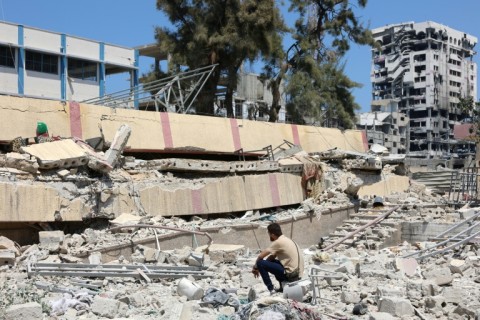 A man looks at the aftermath of an Israeli strike on a school housing displaced Palestinians in the Rimal neighbourhood of central Gaza City