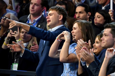 Minnesota Governor and 2024 Democratic vice presidential candidate Tim Walz's son Gus (L) and daughter Hope (2nd L) react as he speaks on the third day of the Democratic National Convention (DNC) at the United Center in Chicago, Illinois, on August 21, 2024