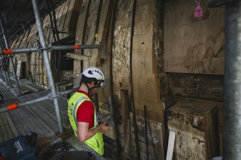 Shipwrights are painstakingly removing and replacing rotten sections of the ship's frames