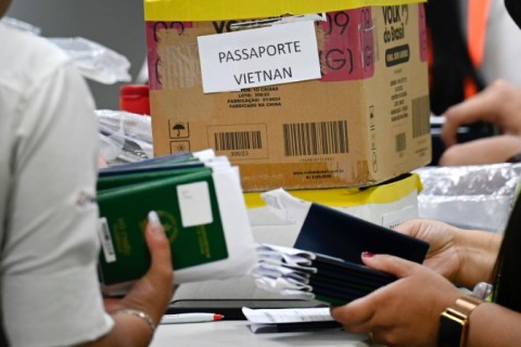  Staff at Guarulhos International Airport group passports of Indian and Vietnamese migrants seeking asylum