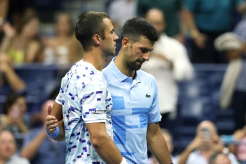 Painful end: Laslo Djere is consoled by  Novak Djokovic after being forced to retire from their second round match