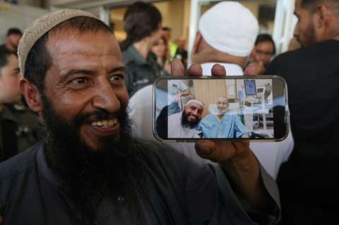 The brother of freed Israeli hostage Kaid Alkadi shows a mobile phone picture of him with another brother