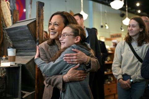 US Vice President and Democratic presidential candidate Kamala Harris hugs a young girl during a campaign stop at Penzeys Spices in Pittsburgh, Pennsylvania