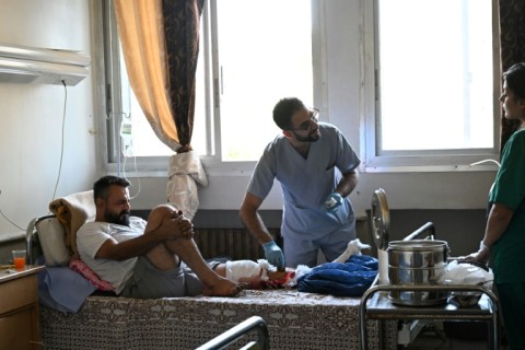 A wounded man receives treatment after the suspected Israeli airstrikes overnight that a Syrian minister said killed 18 people