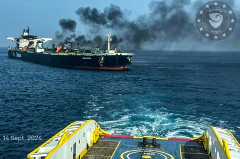 This handout picture provided by EUNAVFOR ASPIDES shows a vessel with a rope extended toward the Greek-owned oil tanker Sounion as smoke and fire billows from it, off the coast of Hodeida in the Red Sea