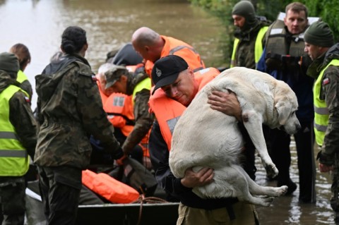 Rescuers evacuate residents and their dog in Rudawa, southern Poland during storm Boris