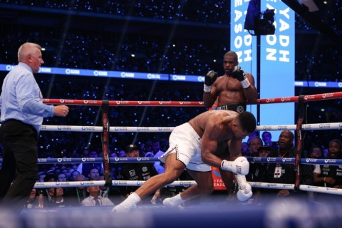 Anthony Joshua is knocked to the ground by Daniel Dubois during their IBF world title fight at Wembley