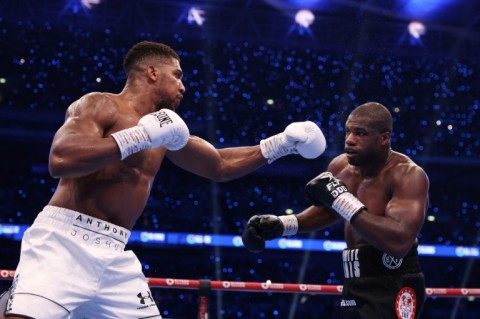 Anthony Joshua (left) throws a punch against Daniel Dubois during their world title fight at Wembley