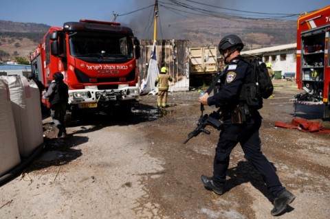 Israeli emergency services respond to a blaze in the border town of Kiryat Shmona ignited by rocket fire from Lebanon