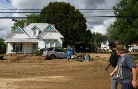 People walk through mud-filled streets in the aftermath of Hurricane Helene in Old Fort, North Carolina