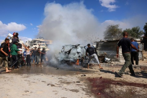 Palestinians at the site of an Israeli strike in Gaza's southern Khan Yunis on October 1