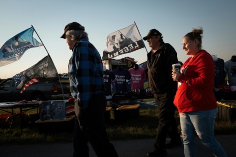 Vendors sell campaign-related merchandise before Republican presidential nominee Donald Trump's rally at Dodge County Airport on October 6, 2024