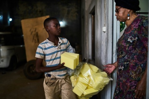 A boy sells bundles of Styrofoam at the coffin workshop