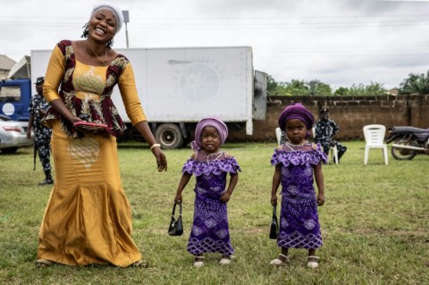 The twins paraded in immaculate matching outfits -- from glamorous sunglasses and patterned adire fabric to a pair of toddlers sporting purple dresses and identical handbags