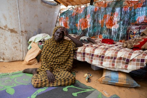 A Sudanese refugee sits inside her shelter in the Adre refugee camp