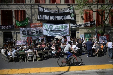 Students take a class in the street outside the faculty of philosophy and letters of the University of Buenos Aires (UBA) in Buenos Aires on October 16, 2024. Students from Argentina's public universities are protesting President Javier Milei's funding cuts