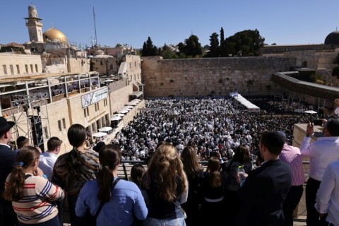 Jewish men, wearing traditional Jewish prayer shawls known as Tallit, gather at the Western Wall in the old city of Jerusalem to perform the annual Cohanim prayer during the holiday of Sukkot