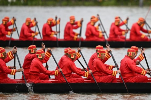 Thai oarsmen row a barge along the Chao Phraya River in Bangkok