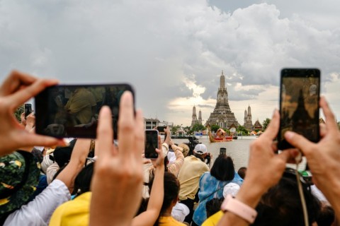 Spectators watch the Royal Barge Procession on the Chao Praya River