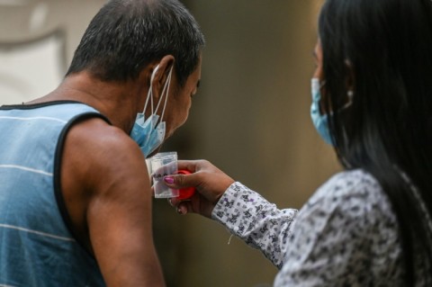 A man spits a sputum sample during a tuberculosis screening at a health centre in Valenzuela in the Philippines