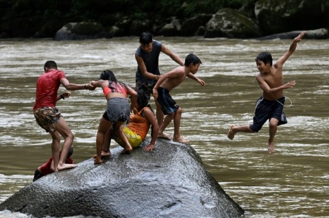 Embera Indigenous children swim in the Atrato river in Colombia's Choco department