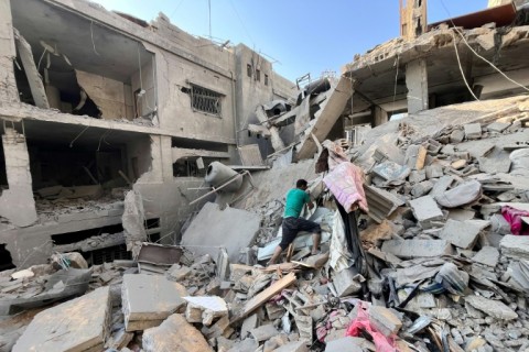 A Palestinian searches for relatives under rubble of building bombed by Israel in Beit Lahia