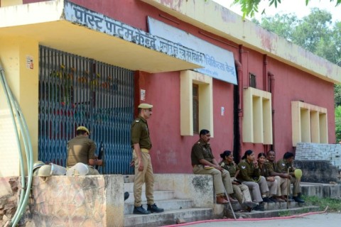 Indian police personnel gather after newborns died in a hospital blaze in Jhansi 