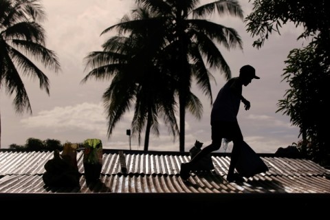 A man puts sandbags on the roof of his house in Legazpi ahead of the anticipated landfall of Typhoon Man-Yi