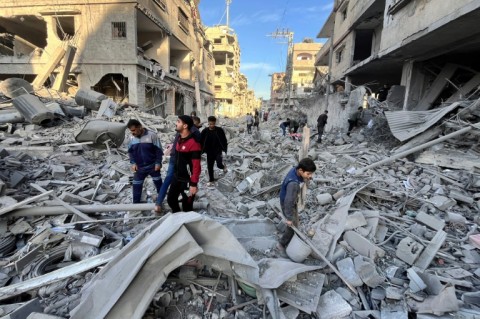 People check the rubble of a building hit in a deadly Israeli strike on Beit Lahia, northern Gaza