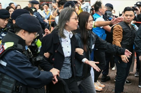 Police detain a woman (C) outside the West Kowloon Magistrates' Court in Hong Kong