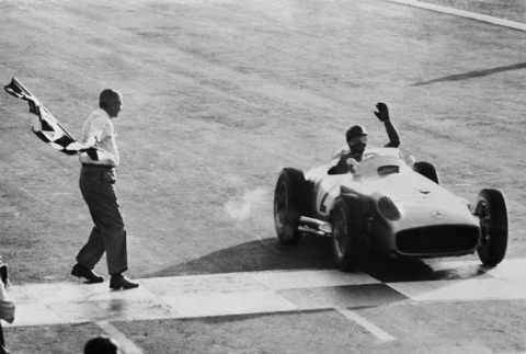 Juan Manuel Fangio in a Mercedes, takes the chequered flag at the opening grand prix of the 1955 season in his home race in Buenos Aires