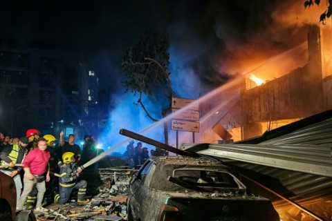 Firefighters douse flames at the site of an Israeli strike on a building in the Lebanese capital