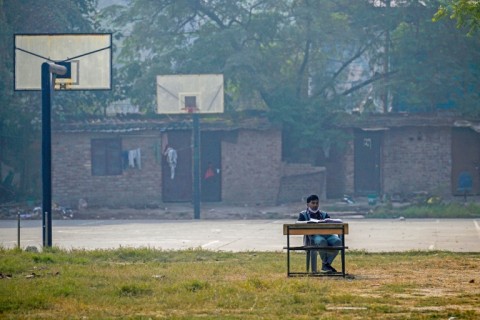 A school teacher conducts an online class near a basketball court at Swami Sivananda Memorial Institute in New Delhi