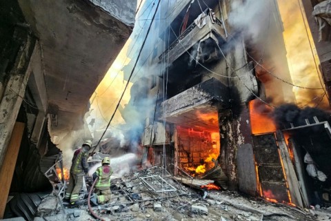 Firefighters battle the flames after a building was hit in an Israeli airstrike in south Beirut