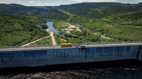 A school bus with tourists crosses the Daniel-Johnson dam over the summer