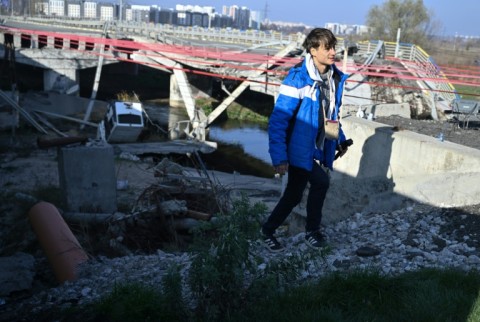 Spanish traveller Alberto Blasco Ventas walks next to the destroyed Irpin bridge in Ukraine which has become a hotspot for thrill-seeking tourists