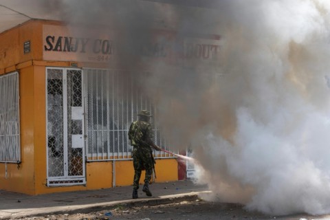 A Mozambique soldier tries to put out a burning tyre during a protest in Maputo Wednesday