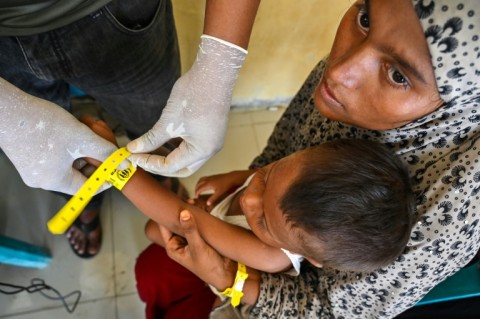 Rohingya refugees receive identity wristbands from UNHCR staff at a temporary shelter in Labuhan Haji, Indonesia